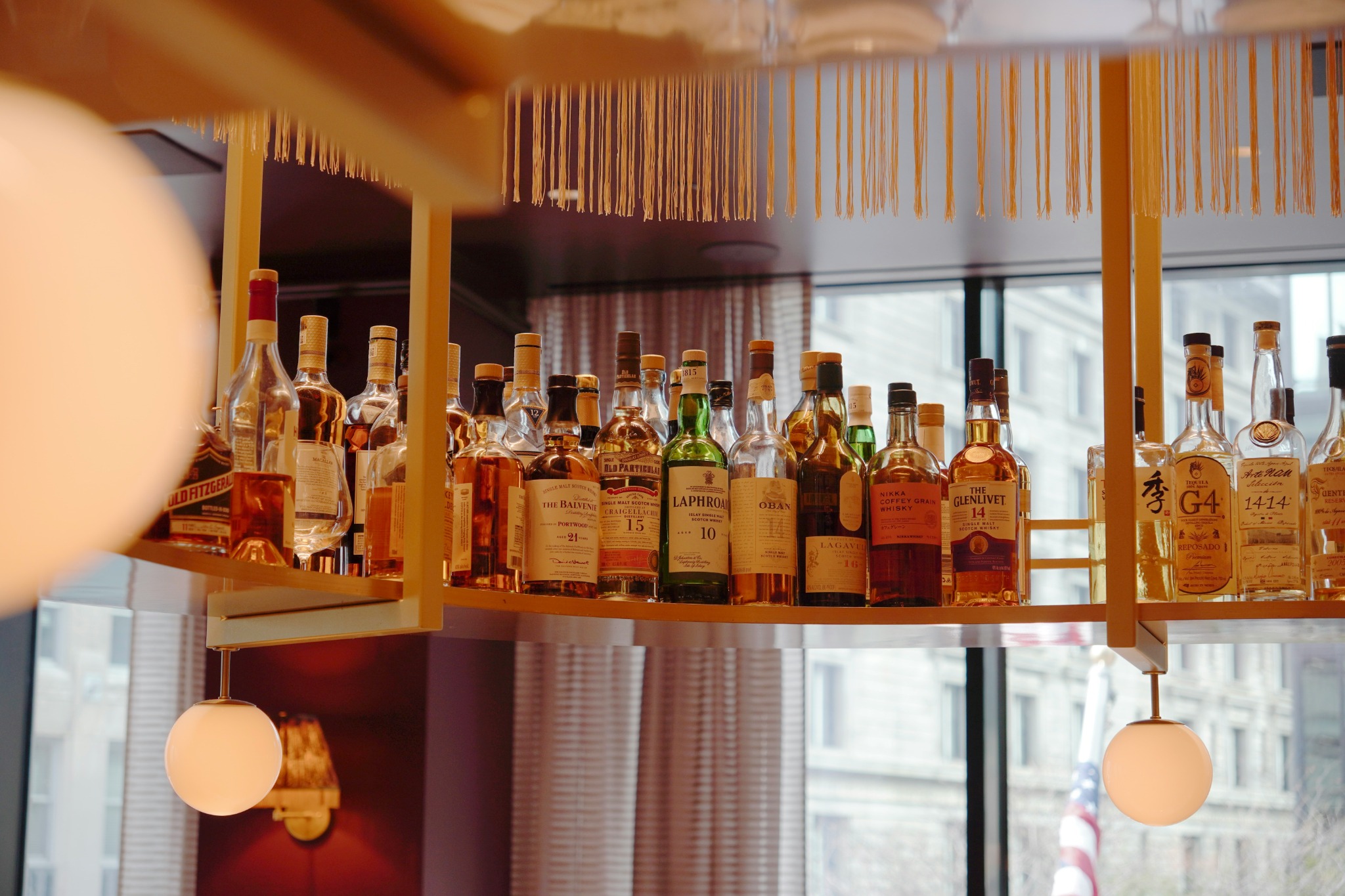 Premium liquor bottles displayed on warm backlit shelves illustrating beverage industry brand positioning